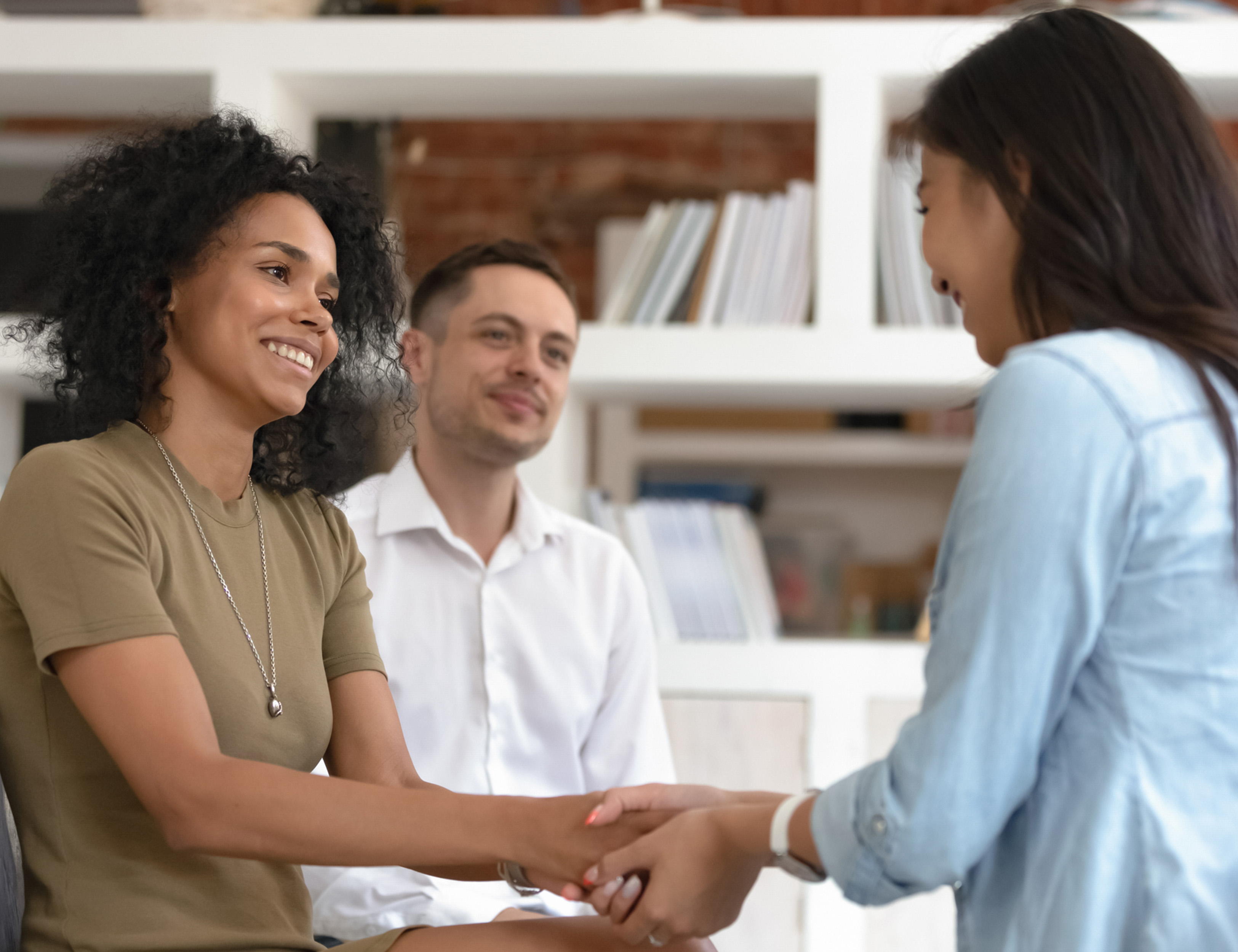 Woman beside spouse holding hands and talking during genetic counseling session