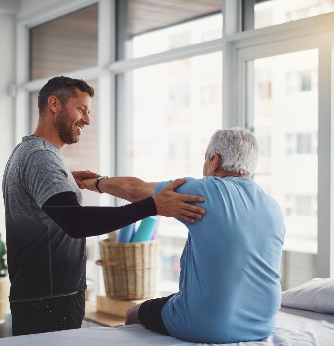 Rehabilitation doctor helping patient stretch arms out