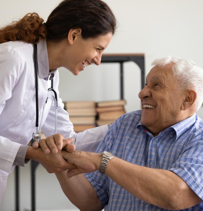 Smiling doctor support comfort older male patient in hospital