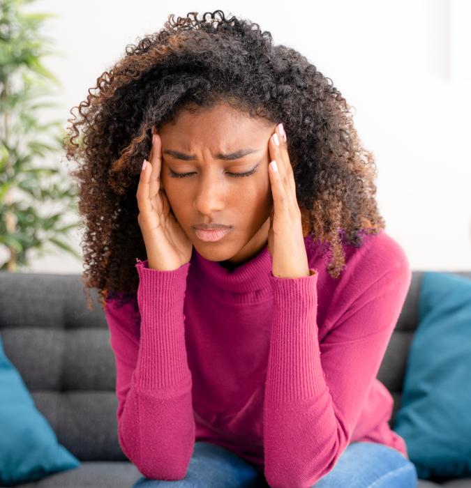 Woman with a migraine holding her head in her hands